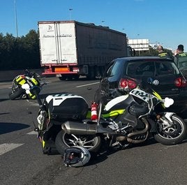 El coche que conducía la sospechosa, con las motos de los dos agentes arrollados.