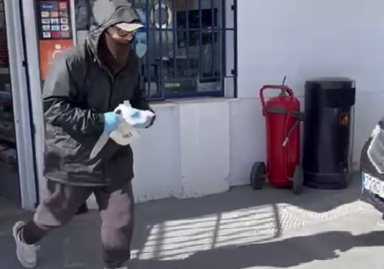 El atracador en el momento que sale de la tienda de la gasolinera.