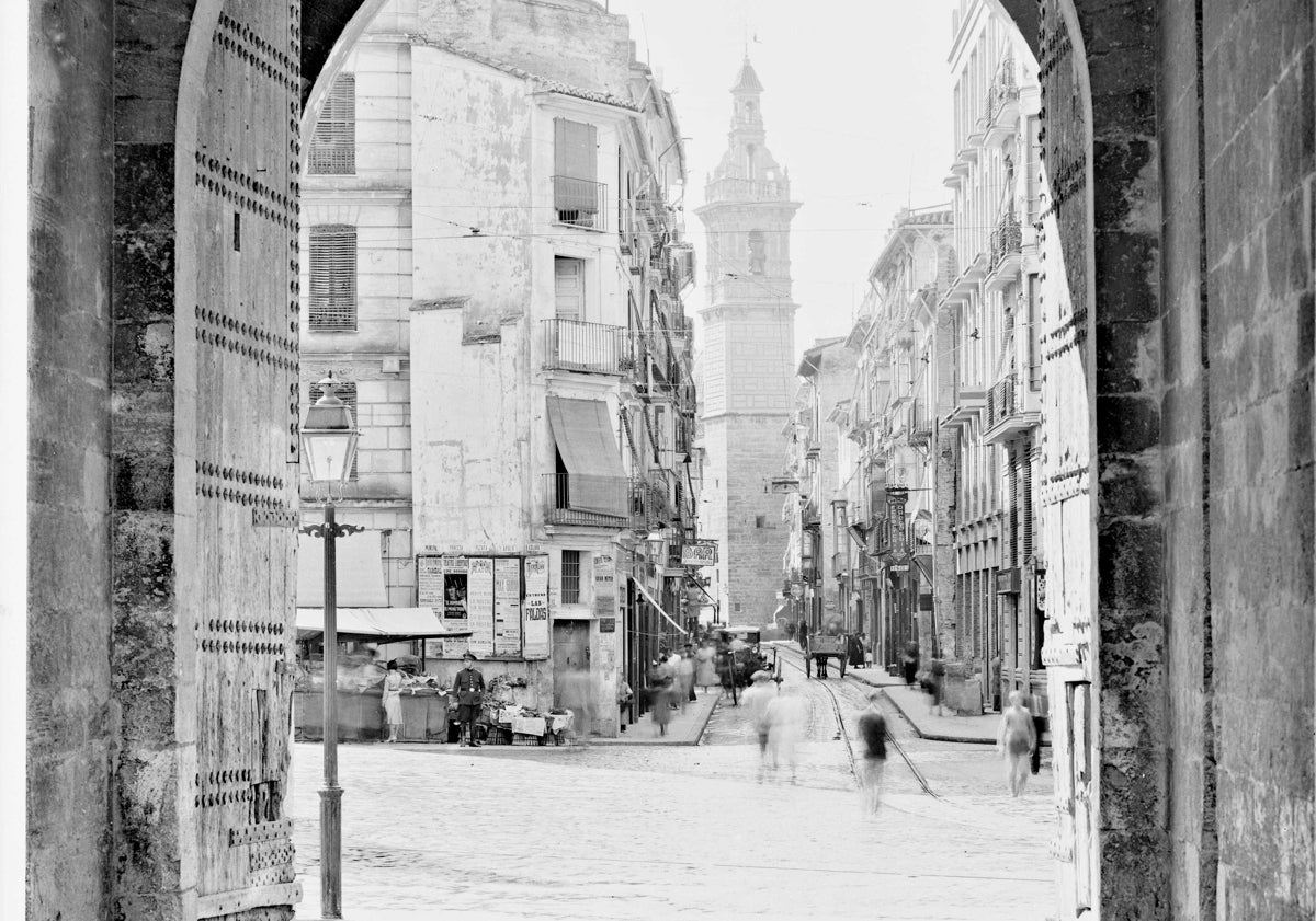 Imagen principal - Vista antigua de la plaza de los Fueros y calle Serranos, con las farolas de iluminación eléctrica y de gas, públicas y privadas, en 1932. Abajo, dos detalles de los restos que se conservan en las calles Arzobispo Mayoral y Ribalta: espita y regata.