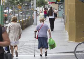 Una anciana con una muleta cruza la calle. Imagen de archivo.