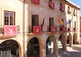 Banderas a media asta en el Ayuntamiento de Dénia junto a los escudos de las comisiones falleras.