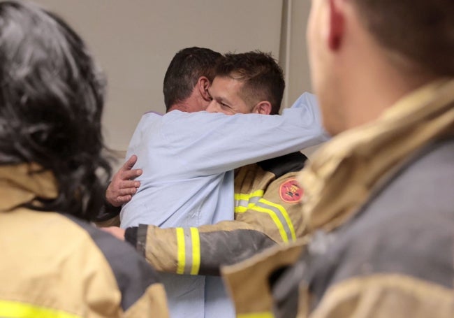 Un emotivo abrazo entre dos bomberos.