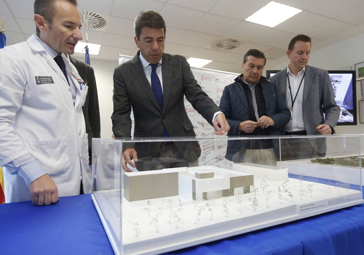 El presidente, Carlos Mazón y el conseller de Sanidad, Marciano Gómez, con responsables de La Fe viendo la maqueta del nuevo edificio este miércoles.