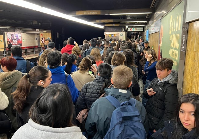 Viajeros agolpados junto a las vías en la estación.