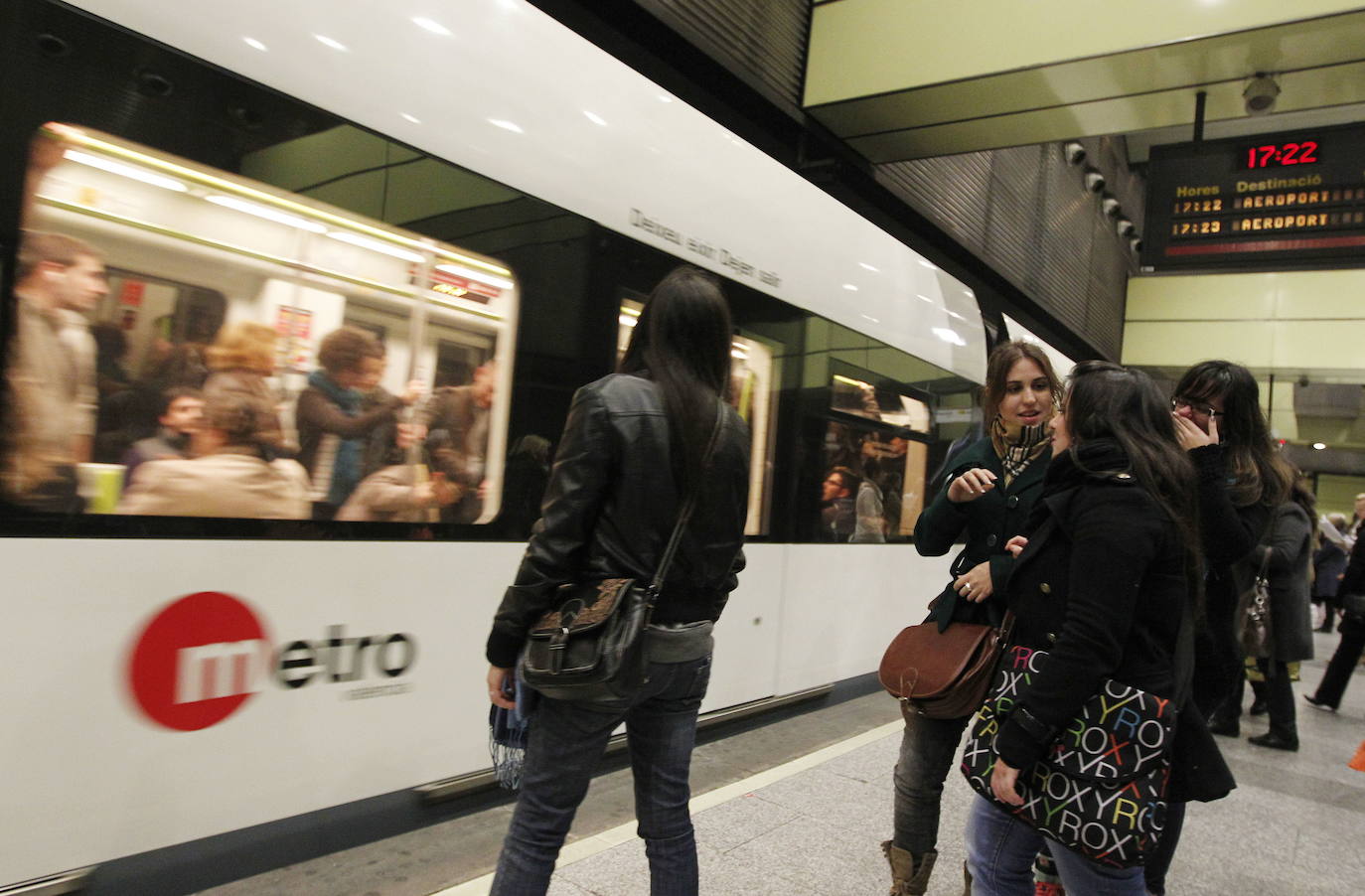 Varios pasajeros en la estación del metro de Colón.