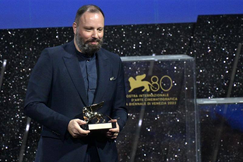 El director griego, Yorgos Lanthimos, autor de 'Pobres Criaturas', sostiene un premio en el Festival de Venecia.