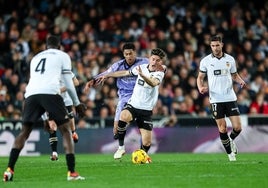 Pepelu es agarrado por Bellingham en el reciente partido Valencia-Real Madrid.