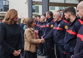 La ministra de Defensa junto a la alcaldesa saludan a los bomberos.