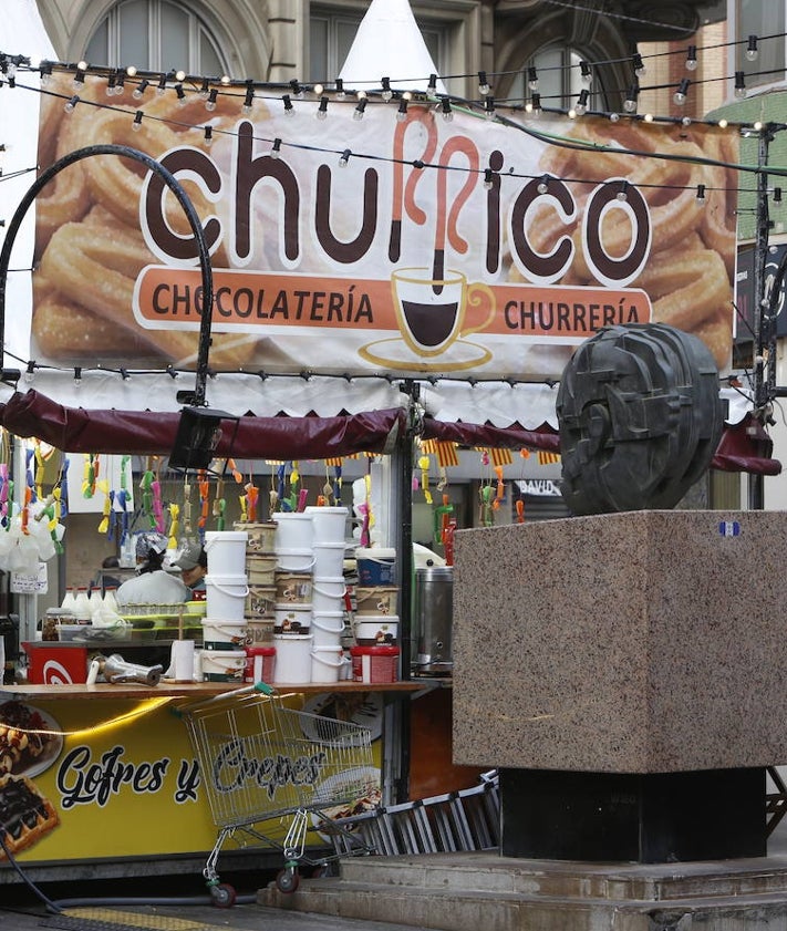 Imagen secundaria 2 - Churrerías instaladas junto a las verjas de la Estación del Norte; instalación junto a las Torres de Quart y busto de Blasco Ibáñez, invadido por un puesto, un carro y una escalera.