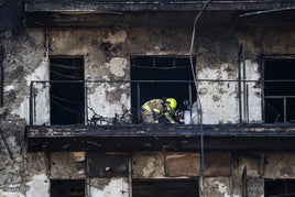 Policía y Bomberos, durante la inspección del edificio incendiado.