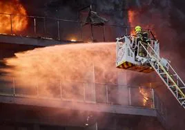 Un bombero hace frente a las llamas en el edificio de Campanar.