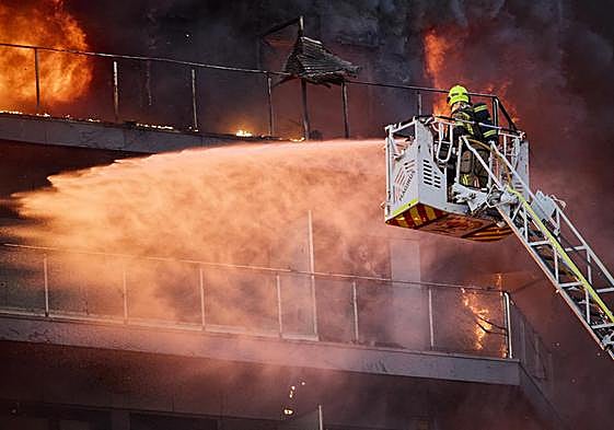 Un bombero hace frente a las llamas en el edificio de Campanar.