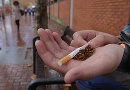 Un joven estudiante, con tabaco, cerca de un instituto,