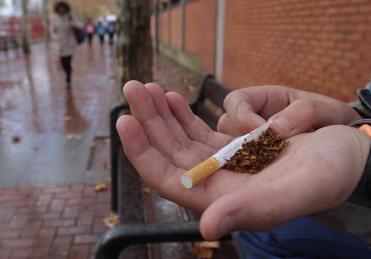 Un joven estudiante, con tabaco, cerca de un instituto,