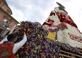 Fallero coloca flores a la Virgen de los Desamparados durante la Ofrenda 2023.