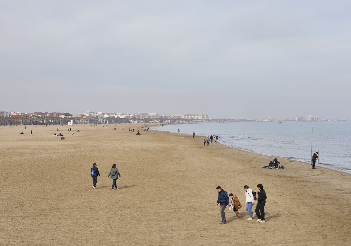 Paseantes en la playa de la Malvarrosa.