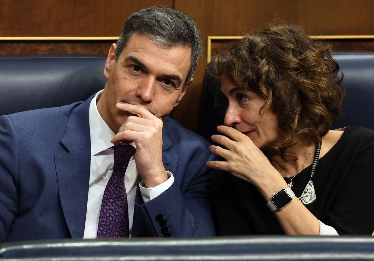 María Jesús Montero conversa con Pedro Sánchez en el Congreso.