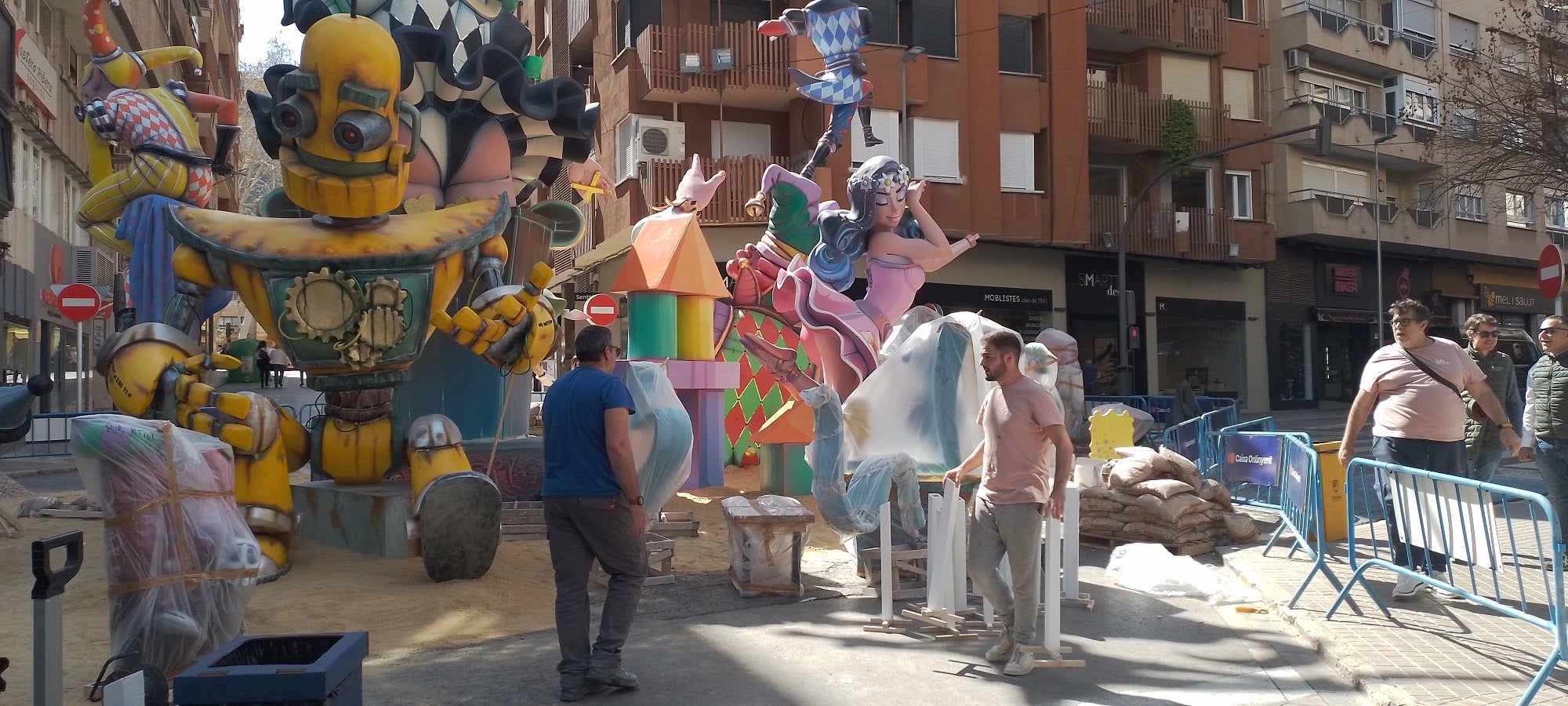 Imagen principal - Arriba, montaje de la falla República Argentina de Xàtiva. Abajo, el monumento de Mercat, entre el mercado ambulante y a la derecha, el de Ferroviaria ya montado.