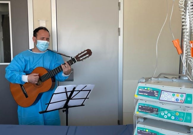 Un músico interpreta una canción en una habitación de un paciente del hosptial LaFe.