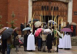 os fieles se cubren con paraguas en Semana Santa.