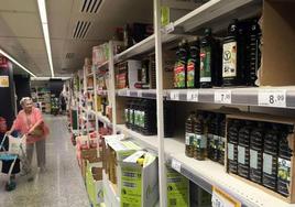 Botellas de aceite de oliva en el lineal de un supermercado.