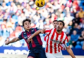 Carlos Álvarez pelea con un rival en el partido contra el Sporting.