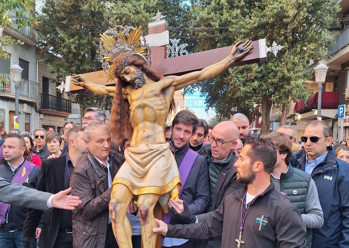 Imagen secundaria 1 - Vestas del la hermandad del Cristo del Salvador y los ediles Juan Carlos Caballero y José Luis Moreno, llevando al Cristo.