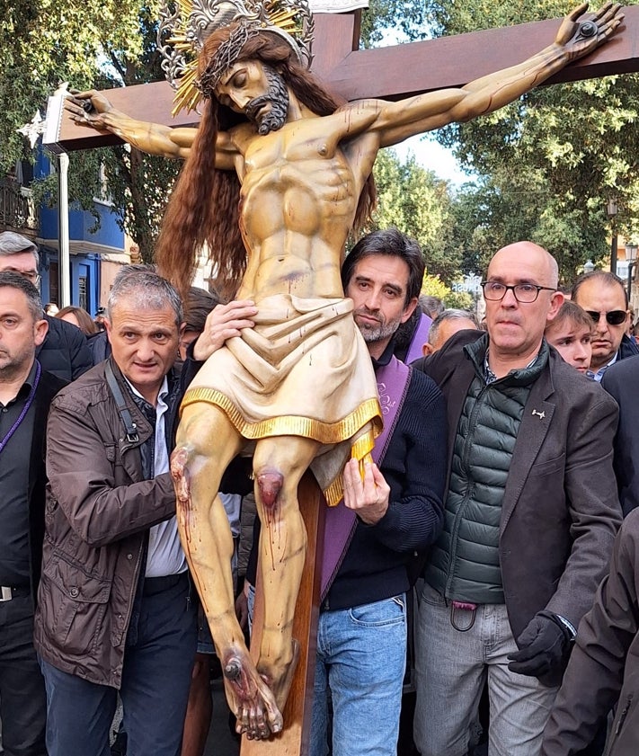 Imagen secundaria 2 - Vestas del la hermandad del Cristo del Salvador y los ediles Juan Carlos Caballero y José Luis Moreno, llevando al Cristo.