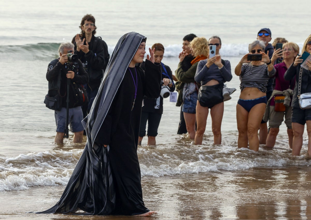 Imagen secundaria 1 - Visita a la playa y ofrenda de la corona de laurel y una devota, pasando un pañuelo al Cristo.