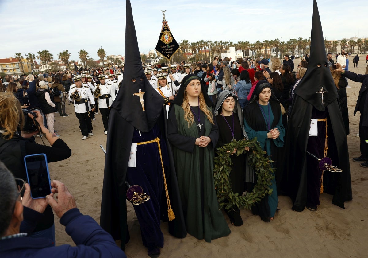 Las Tres Marías de la Hermandad del Santísimo Cristo del Salvador: Mamen Cambrils (i); Ariadna Masiá y Andrea Ballester, en la ofrenda de la corona de laurel, a orillas del mar.