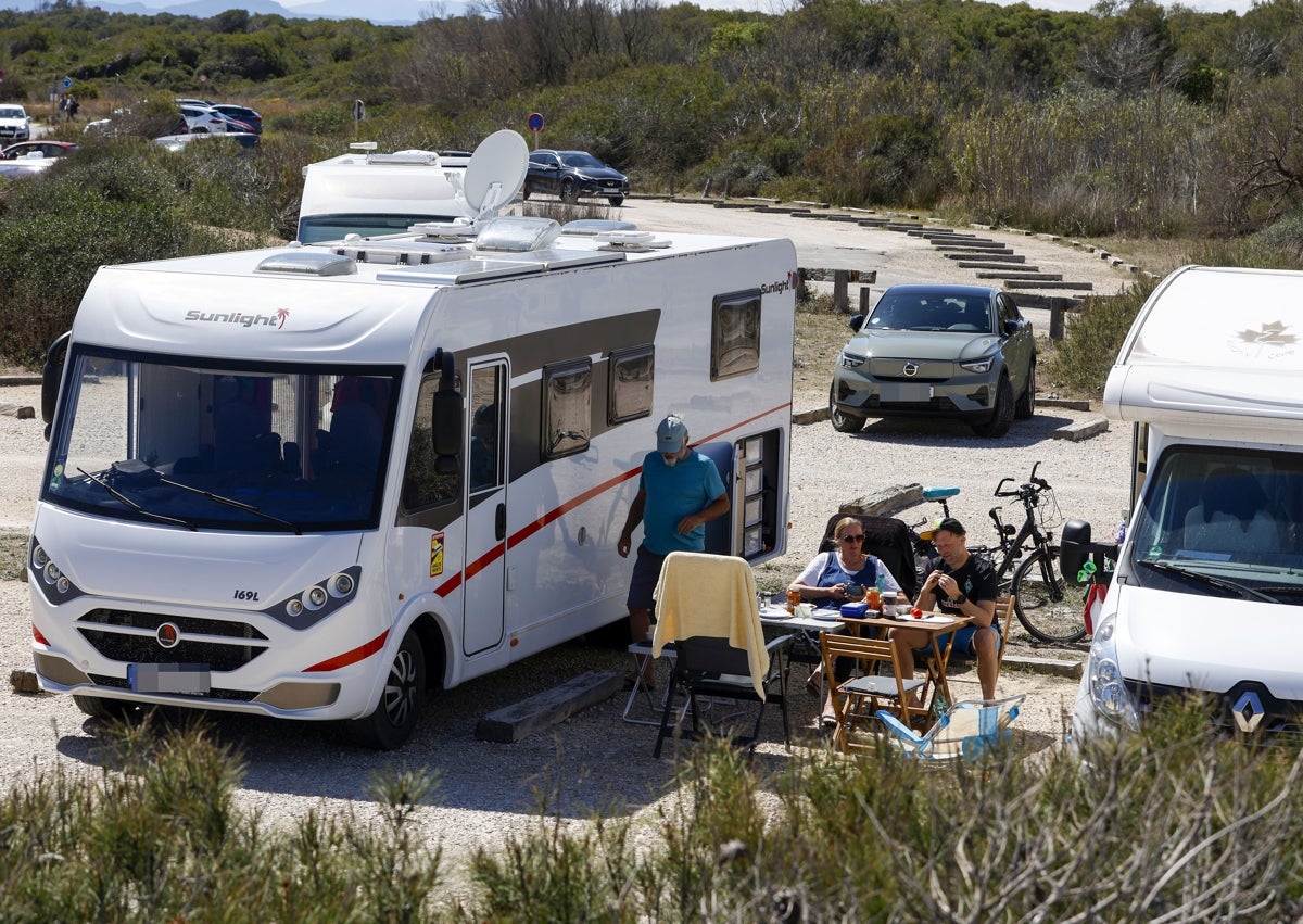 Imagen secundaria 1 - Cartel donde se indica la prohibición de acampar; picnic entre caravanas y gran camión en el parking de la playa de El Saler.