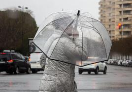 Una mujer se protege de la lluvia en una imagen de archivo.