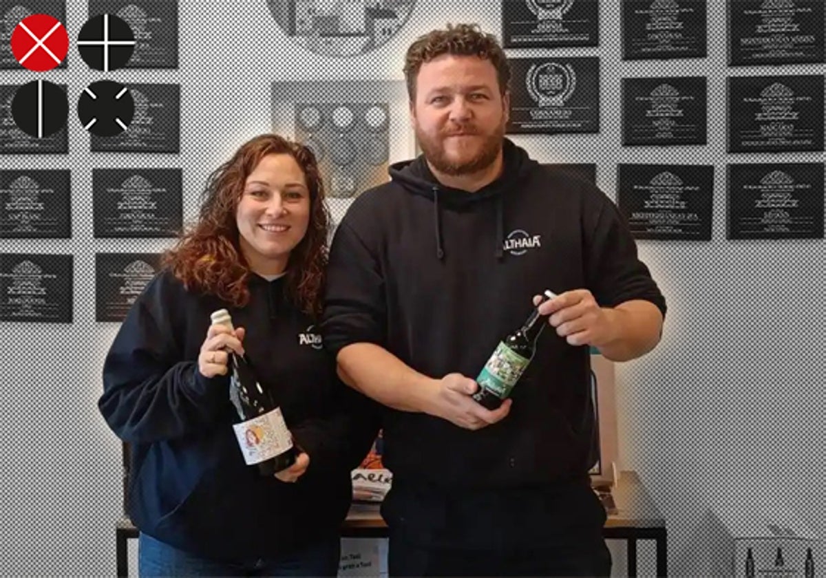 Los fundadores de la compañía cervecera, Mayte y Jorge, posan con cervezas delante de la pared que exhibe los premios conseguidos.