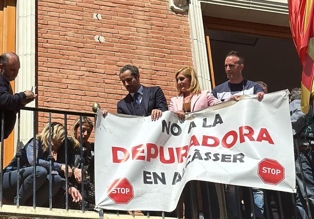 El alcalde y la consellera retiran la pancarta contraria a la depuradora en el Ayuntamiento de Alcàsser.