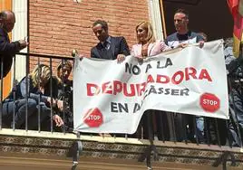 El alcalde y la consellera retiran la pancarta contraria a la depuradora en el Ayuntamiento de Alcàsser.