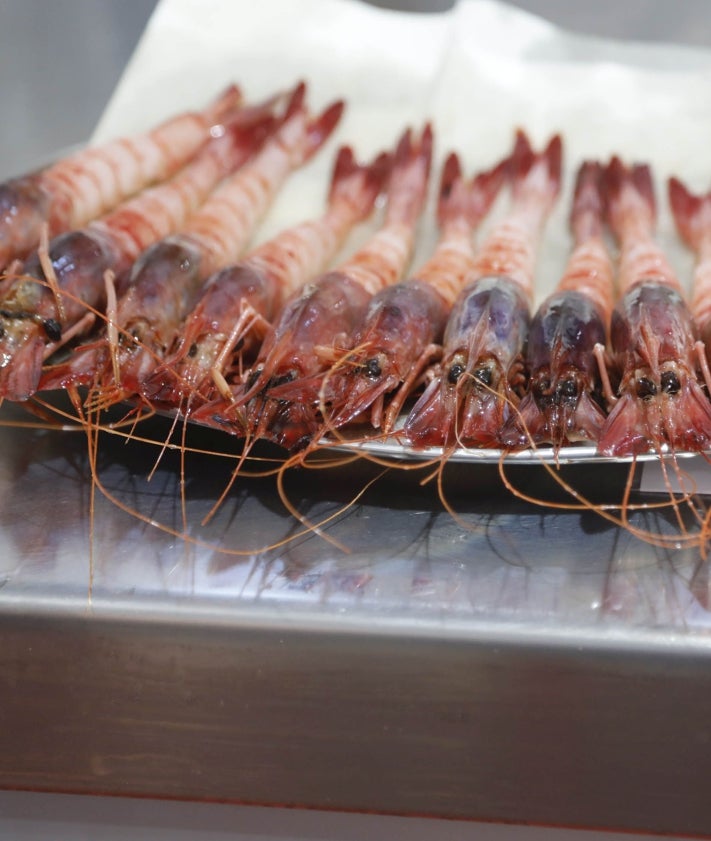 Imagen secundaria 2 - La mesa con los platos de los ocho finalistas, los tres mejores clasificados sobre el escenario y las protagonistas del certamen, las gambas rojas de Dénia que aporta la Cofradía de Pescadores.