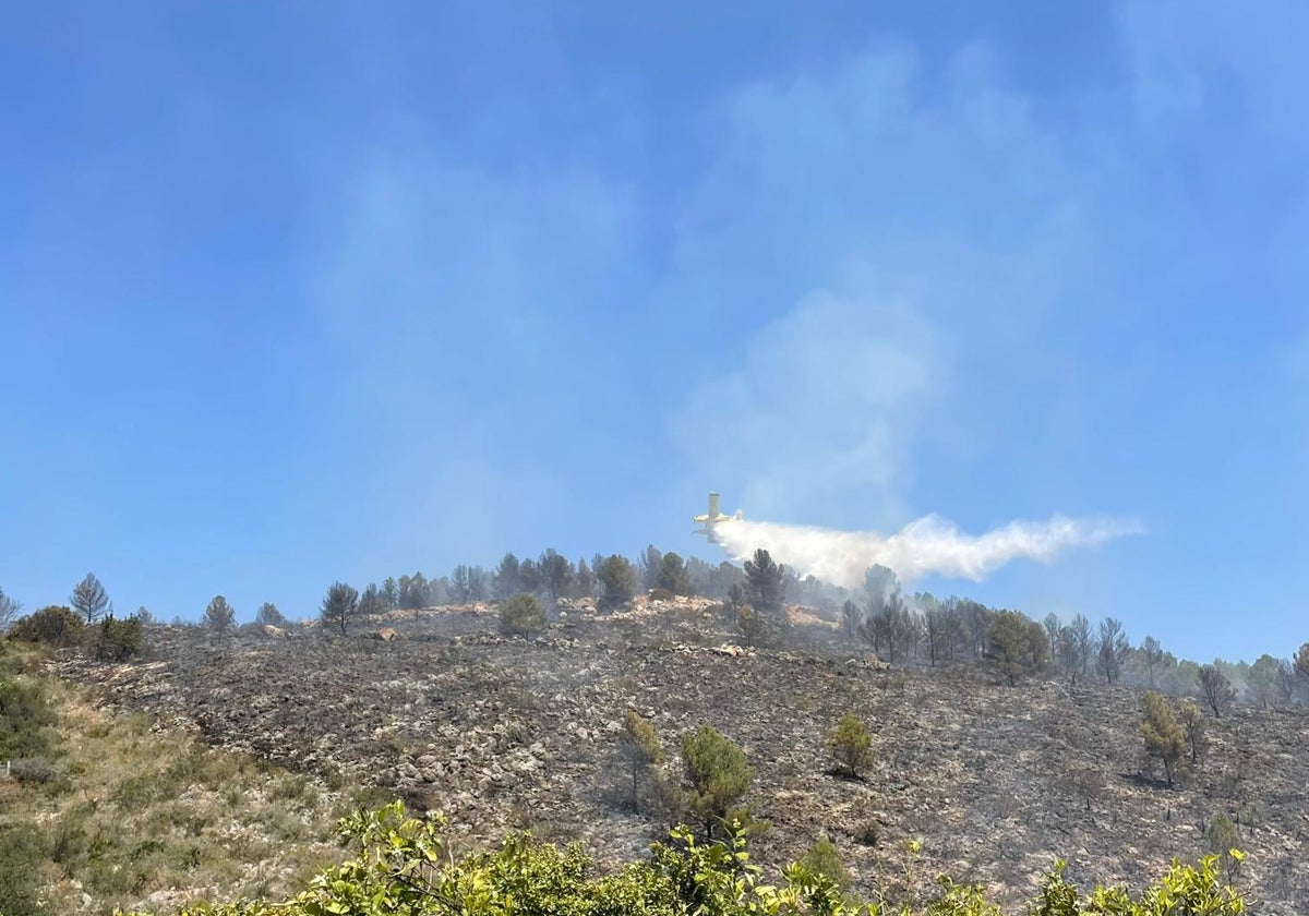 Un avión trabaja para acabar con el fuego en Benifairó.