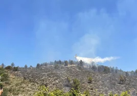 Un avión trabaja para acabar con el fuego en Benifairó.