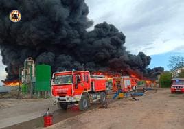 Los bomberos se afanan en evitar que las llamas se extiendan a las naves de la planta.