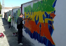Jóvenes haciendo un graffiti en una imagen de archivo.
