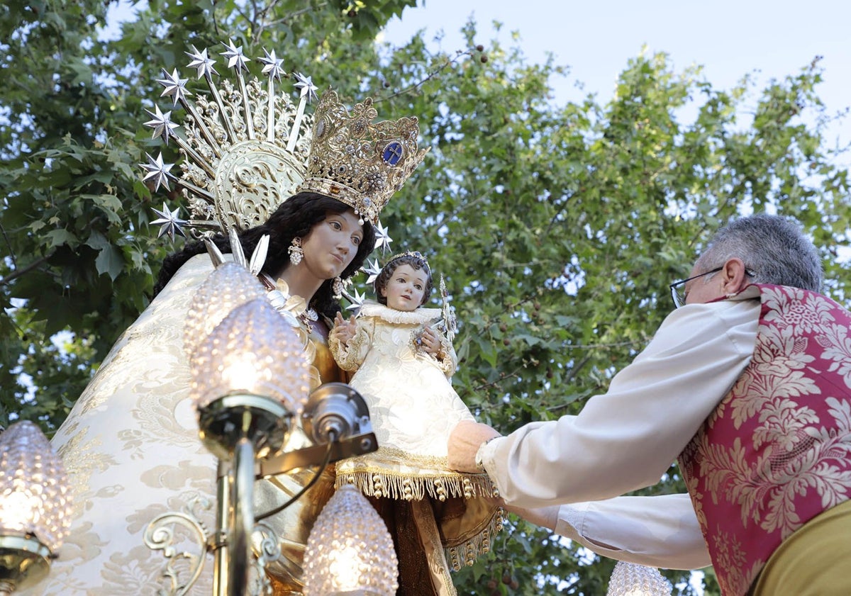 Imagen principal - Visita de la Peregrina, al barrio valenciano de Ruzafa y Guillermo Serrano, presidente de la agrupación de fallas de Ruzafa, con la imposición de una insignia conmemorativa a la Virgen.