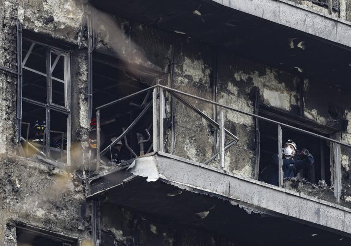 Un investigador inspecciona uno de los balcones destruidos por el fuego.