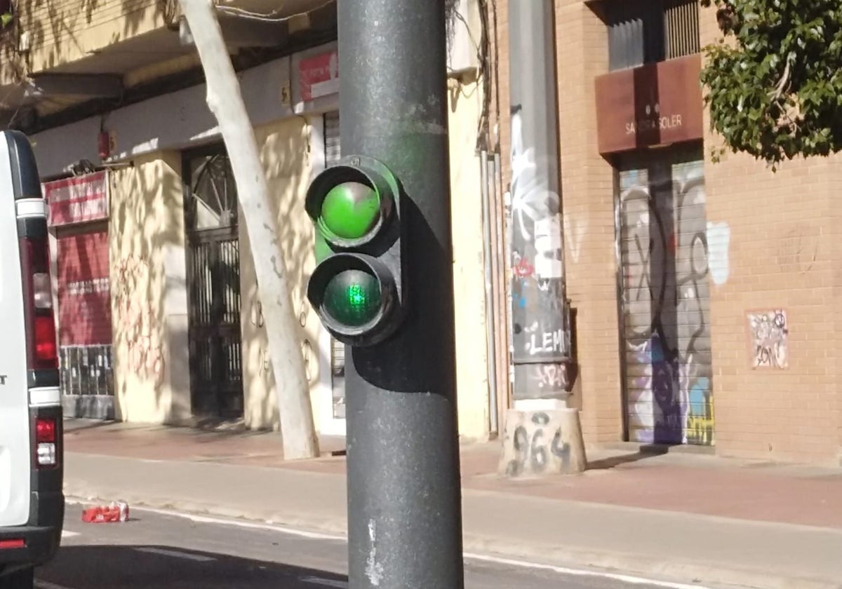 El disco rojo pintado de verde, en uno de los semáforos de baja altura de la calle Almassora de Valencia