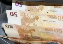 Una máquina cuenta y clasifica billetes de cincuenta euros en un banco.