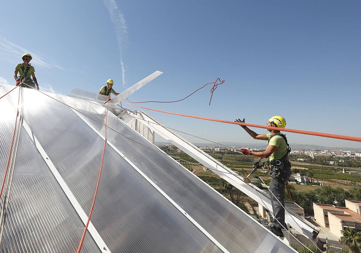 Grupo de trabajadores realizando tareas verticales en la cubierta de un edificio.