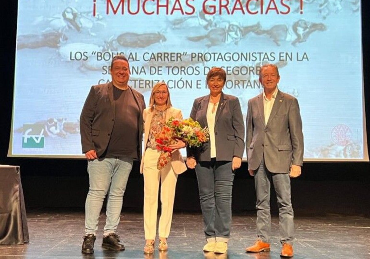 María Jesús Gamón, en el acto de reconocimiento agasajada con un ramoi de flores.