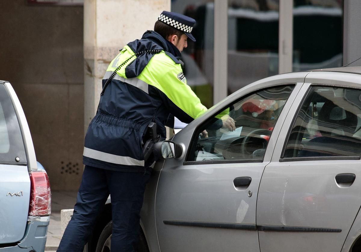 Un agente de la Policía multando a un coche en una imagen de archivo.