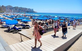 Turistas salen de la playa de Benidorm.