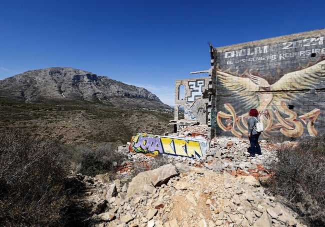 Grafitis pintados en una de las paredes del Greco y el macizo al fondo.