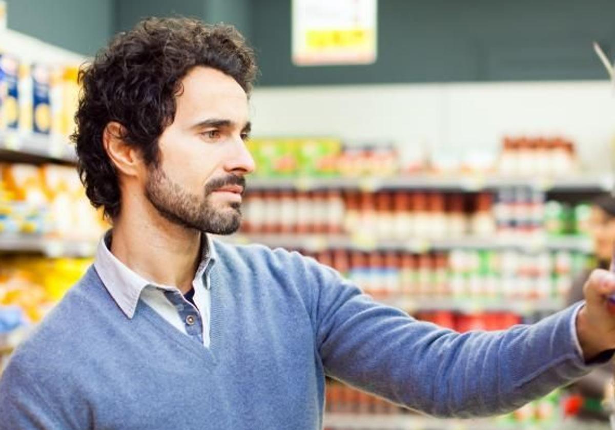 Un hombre elige alimentos en un supermercado.